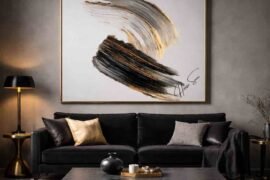 Emotional interior design featuring black, gold, and gray abstract artwork above a black velvet sofa in a moody luxury living room.